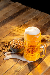Draft beer in glasses and peanut on wooden surface