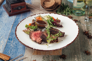 Tender steak mignon with greens and sauce