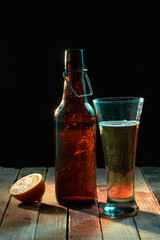 Dark crafted beer in glass and bottle on black background