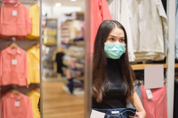 Fototapeta premium woman with face mask is shopping clothes in Shopping center