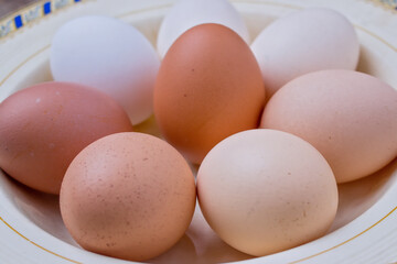 eggs of different colors in an old plate - closeup