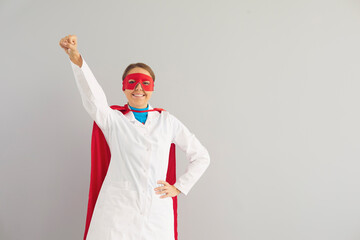 Superhero medical doctor in red cape fighting with virus on grey background, copy space. Medicine...