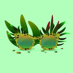 Crocodile print glasses in tropical leaves on background