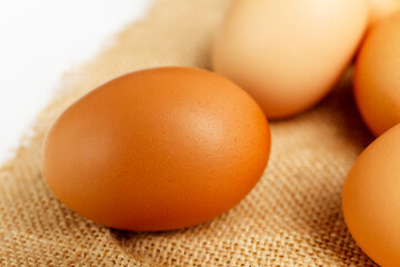 Close up fresh chicken egg on linen tablecloth with copy space.  Fresh chicken egg with blur eggs background.