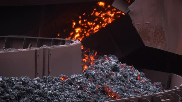 Close up view of the conveyor delivers a hot coal. Mining equipment.