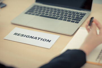 An employee resignation letter is placed on the personnel manager's desk in the office.