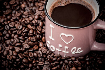 a mug filled with black coffee and beans in the background