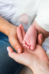 Obraz na płótnie Canvas Parents hold in the palm of their hand the newborn’s leg.