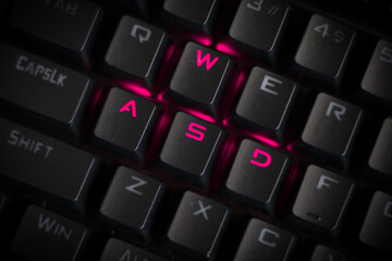 WASD keys light up in magenta on RGB mechanical gaming keyboard. WASD keys used for walking in games