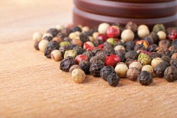 A mixture of peppers. Black, white, red polka dots. Isolated on a wooden background. The selected sharpness