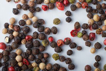 A mixture of peppers. Black, white, red polka dots. Isolated on a white background. The selected sharpness