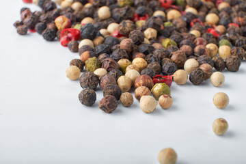 A mixture of peppers. Black, white, red polka dots. Isolated on a white background. The selected sharpness