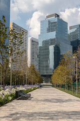 Entrance to La Mexicana park in Santa Fe, Mexico City with metal benches and glass building in the back
