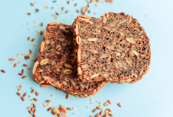 Sliced whole grain bread rye with seeds flax, sunflower, pumpkin and sesame.Healthy food, eco-friendly natural products. Fresh bread on a pink background.