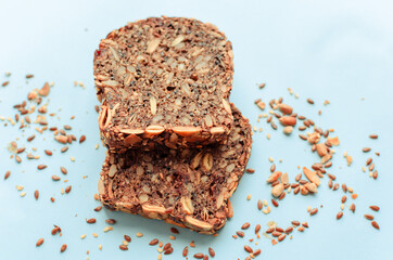 Sliced whole grain bread rye with seeds flax, sunflower, pumpkin and sesame.Healthy food, eco-friendly natural products. Fresh bread on a pink background.