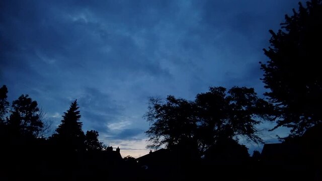 Sunset in the late evening against a silhouette of a tree line, timelapse