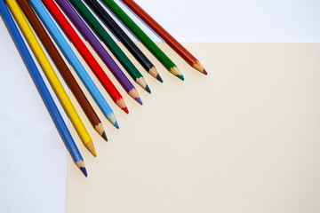 color pencils on a piece of paper on a light background