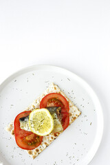 Salty crackers with sardine, tomato and lemon from above