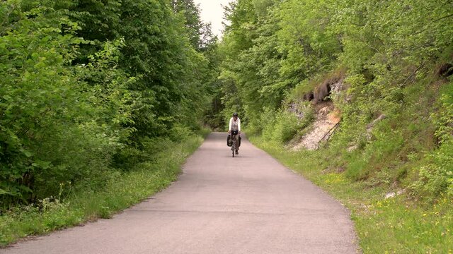 Man cycling through calm road, Zumberak national park, Croatia.