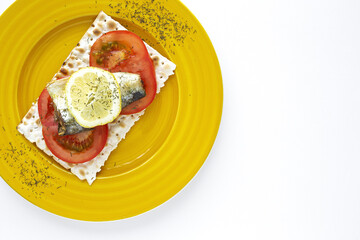 Salty crackers with sardine, tomato and lemon from above