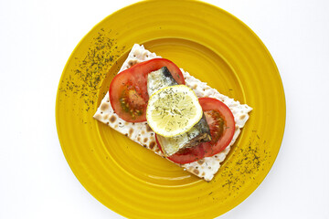 Salty crackers with sardine, tomato and lemon from above