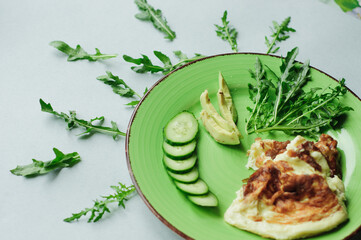 a still-life with scrambled eggs, fresh cucumbers and fried potatoes with meat. neatly and beautifully decorated meal