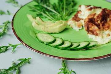a still-life with scrambled eggs, fresh cucumbers and fried potatoes with meat. neatly and beautifully decorated meal