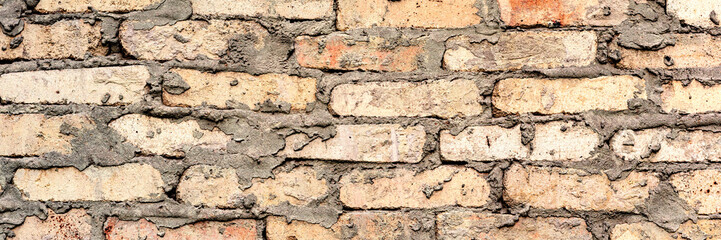 Texture of a brick wall with cracks and scratches which can be used as a background