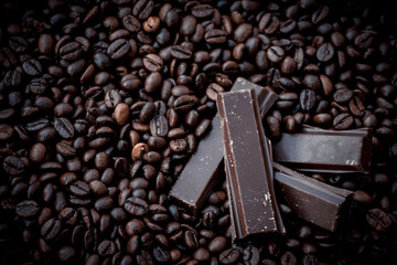 sweet and tasty dark chocolate bars surrounded by coffee beans