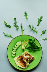 a still-life with scrambled eggs, fresh cucumbers and fried potatoes with meat. neatly and beautifully decorated meal