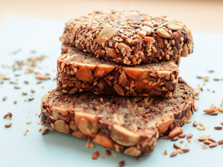 Sliced whole grain bread rye with seeds flax, sunflower, pumpkin and sesame.Healthy food, eco-friendly natural products. Fresh bread on a pink background.