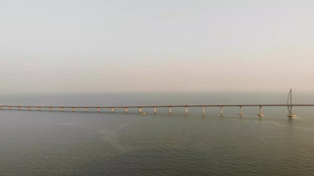 Panning aerial shot of famous Hong Kong - Zhuhai - Macau Bridge during golden hour