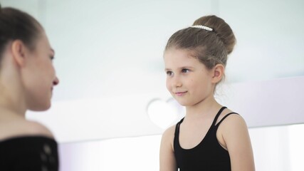 Cute Female ballet teacher gives his sad student a toy