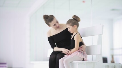 Fototapeta na wymiar Cute Female ballet teacher reassures his sad student