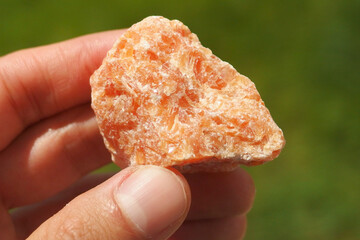 Orange Calcite mineral from  Brazil held in a hand
