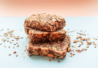 Sliced whole grain bread rye with seeds flax, sunflower, pumpkin and sesame.Healthy food, eco-friendly natural products. Fresh bread on a pink background.