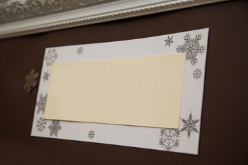
White frame with a beige insert for text with an ornament of snowflakes around the perimeter on a...