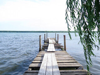 An old dilapidated wooden pier on a lake. Desolate region.