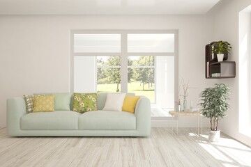 White living room with sofa and summer landscape in window. Scandinavian interior design. 3D illustration