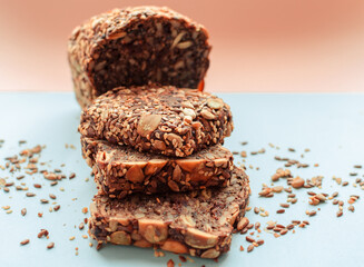Sliced whole grain bread rye with seeds flax, sunflower, pumpkin and sesame.Healthy food, eco-friendly natural products. Fresh bread on a pink background.