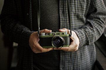 man in shirt man hands holds film camera retro camera . Horizontal