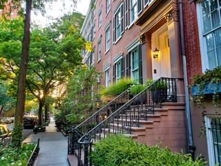 Old brownstone buildings along a quiet street in the West Village neighborhood of Manhattan in New...