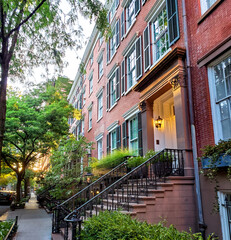Fototapeta na wymiar Old brownstone buildings along a quiet street in the West Village neighborhood of Manhattan in New York City NYC