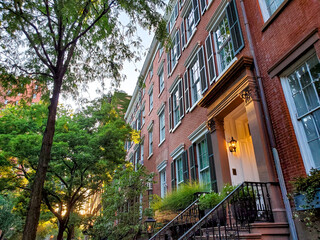 Old brownstone buildings along a quiet street in the West Village neighborhood of Manhattan in New...