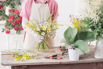 girl florist makes  bouquet of wildflowers