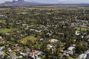 Aerial view of rural Mexico City, over the agricultural parts of Xochimilco, with floating gardens, fields, greenhouses and typical trees