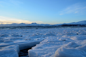 Ice covered sea shore in the arctic circle on a sunny clear blue day
