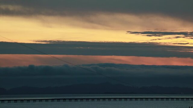 Time-lapse Dusk along the straight low section of Astoria Megler bridge Oregon to Washington slow moving clouds through center