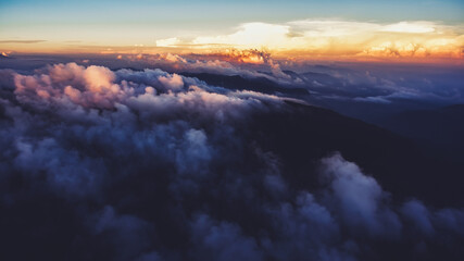 Aerial photo from airplane cockpit of a wonderful landscape of skies with white clouds and sunset rays. View from plane of a beautiful sky scenery with sunrise. Perfect outdoors background for website