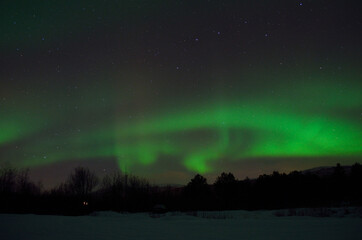 magnificent aurora borealis over frozen river bed and snowy mountain in the cold arctic circle night